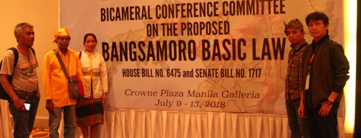 Indigenous Peoples Leaders standing in front of a banner of the Bicameral Conference Committee in the Proposed Bangsamoro Basic Law